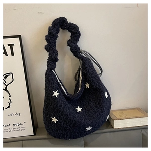 Dettaglio della borsa hobo in peluche blu scuro con stelle ricamate e manico intrecciato