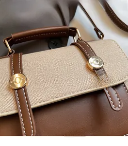 Close-up of vintage contrast stitching and textured canvas fabric with gold logo