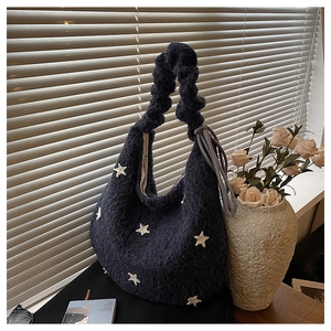 Dettaglio borsa tote in peluche blu navy con stelle bianche e tracolla arricciata