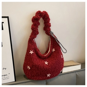 Dettaglio borsa hobo in pile rosso con stelle rosa e manico arricciato