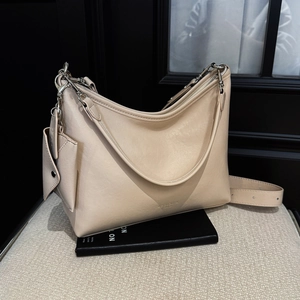 Détail du sac hobo avec chaîne argentée, mini pochette et bandoulière réglable