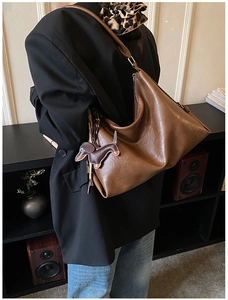 Dettaglio della borsa hobo marrone vintage con un simpatico ciondolo in pelle a bassotto