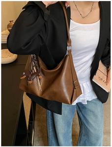 Dettaglio della borsa tote in pelle PU marrone con un piccolo ciondolo a forma di cane