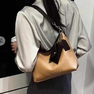 Détail du sac cabas minimaliste en cuir gingembre et café foncé avec petite pochette