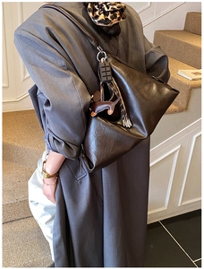 Borsa tote vintage marrone scuro con charms abbinata a un trench coat grigio