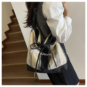 Dettaglio borsa tote in lana a righe con ricamo Axima e fiocchi decorativi con coulisse