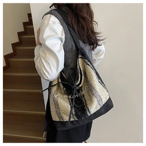 Dettaglio della borsa tote in tweed con motivo scozzese bianco e nero e ricamo animal