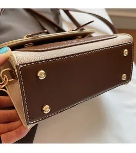 Detail view of the brown leather handbag base with four golden protective metal studs