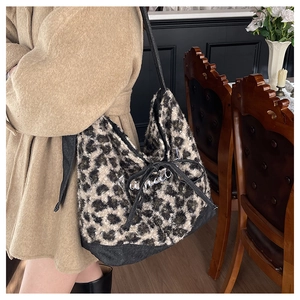 Dettaglio borsa tote in peluche leopardata con fiocco a coulisse nero e logo in metallo