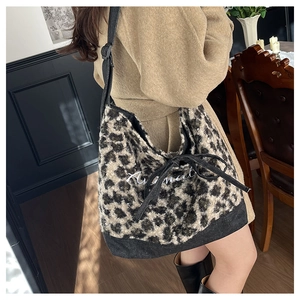 Dettaglio della borsa tote in peluche leopardato con ricamo bianco e chiusura a coulisse