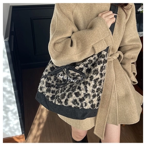Dettaglio della borsa tote in ecopelliccia leopardata con ricamo bianco e manici neri