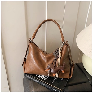 Borsa hobo vintage marrone con ciondoli a forma di cioccolato e bassotto sopra dei libri