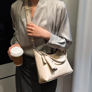 Vue détaillée du sac bandoulière demi-lune crème avec sangle réglable et mini pochette