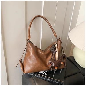 Dettaglio della borsa hobo vintage marrone con ciondoli a cioccolato e bassotto