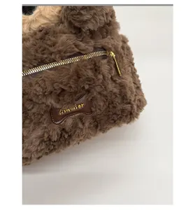 Macro detail of plush brown faux fur fabric with a bone-shaped leather brand tag