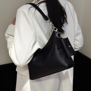 Détail du sac hobo en cuir noir avec ferrures argentées et petite pochette à monnaie
