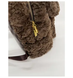 Detail of high-quality golden double metal zippers on fluffy dark brown plush backpack