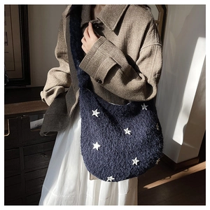 Dettaglio borsa tote in peluche blu navy con pelliccia sintetica e toppa a stella bianca