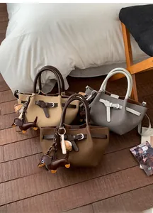 Detailansicht modischer Handtaschen in drei Farben mit dekorativen Gürtelschnallen