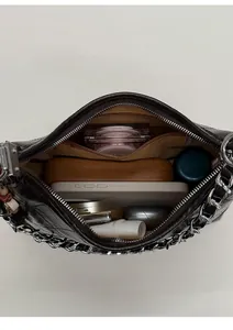 Internal view of dark brown quilted leather shoulder bag showing spacious storage capacity