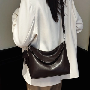 Vue détaillée du sac cabas en cuir marron foncé porté à l'épaule pour un style décontracté