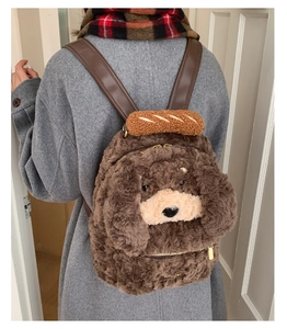Close-up of cute plush puppy backpack with a toy baguette detail on a grey coat