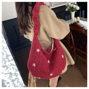 Dettaglio della borsa tote in peluche rossa con stelle rosa e zip in metallo