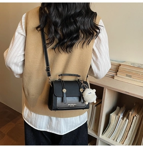 Retro black crossbody bag with decorative buckles and a cute white plush sheep charm