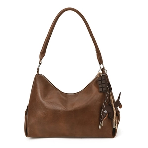 Grande borsa tote retrò marrone con ciondoli decorativi su sfondo bianco stile vintage