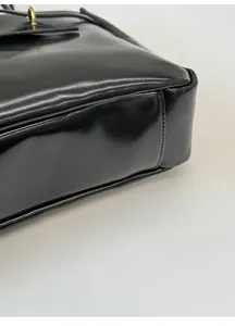 Detail of reinforced wide base design for black leather tote bag showing solid structure