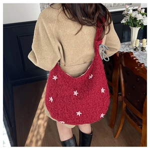 Dettaglio della borsa a tracolla rossa in peluche a mezzaluna con stelle rosa e tracolla