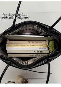 Detail view of spacious interior with striped lining and zipper pocket for tote bag