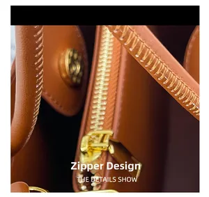Makroaufnahme einer braunen Ledertasche mit Reißverschlussdesign und goldener Magnetschnalle