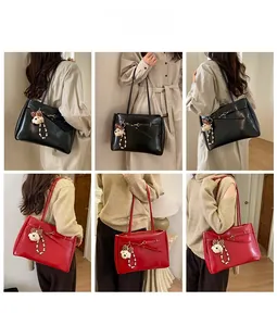 Detail view of large tote bags in black and red with pearl bear charm and metal buckle