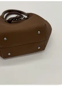 Detail des breiten Handtaschenbodens mit Kieselleder und schützenden Metallnieten