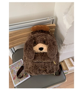 Close-up of fluffy brown puppy backpack with croissant handle and gold metal zippers