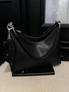 Sac fourre-tout minimaliste en cuir noir avec détails argentés sur des livres noirs
