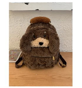 Detailed macro of plush dog backpack with golden zipper pocket and adjustable straps
