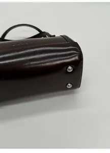 Macro shot of dark brown polished leather bag bottom with protective silver studs