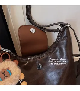 Detail of vintage brown leather bag showing magnetic closure and internal zipper