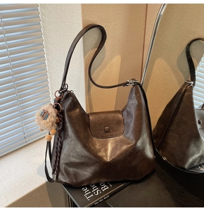 Detailed view of dark brown hobo bag with vintage texture and cute plush sheep charm