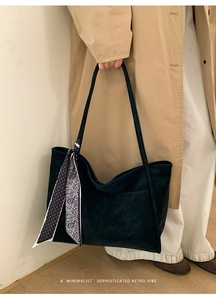 Detail of black tote bag with suede texture and decorative polka dot silk scarf detail