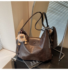 Close-up of deep brown vintage tote bag with sheep pendant and magnetic closure