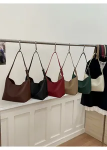 Bolsos hobo de piel con grano lichi en seis colores colgados en un soporte de metal