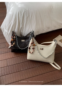 Close-up of quilted chain bags with silver locks and decorative beaded plush charms