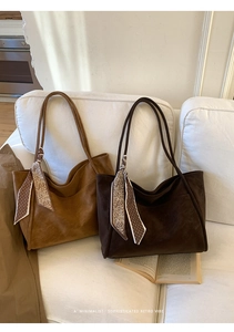 Detail of suede textured tote bags in brown and dark coffee with decorative silk scarves