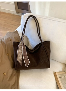 Macro detail of dark brown suede tote bag with a vintage polka dot silk scarf handle decor