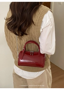 Detail of burgundy wax leather Boston bag featuring silver hardware and a vintage aesthetic