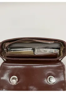 Interior view of small vintage crossbody bag showing main compartment and storage capacity