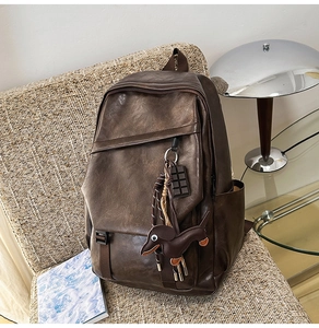 Close-up of a vintage dark brown leather backpack with cute dog and chocolate charms
